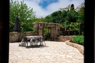 a patio with a table and chairs and an umbrella at Villa Jovana in Zagora