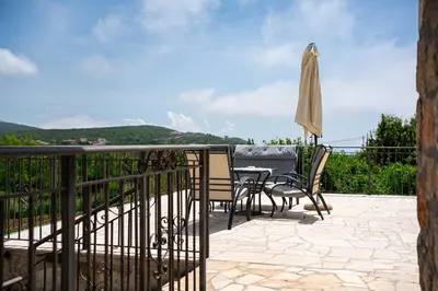 a patio with a table and chairs and an umbrella at Villa Jovana in Zagora
