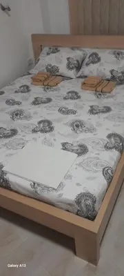 a bed with a black and white comforter on it at Apartman Tijana in Sutomore