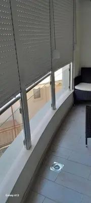 a view of a room with windows and a couch at Apartman Tijana in Sutomore