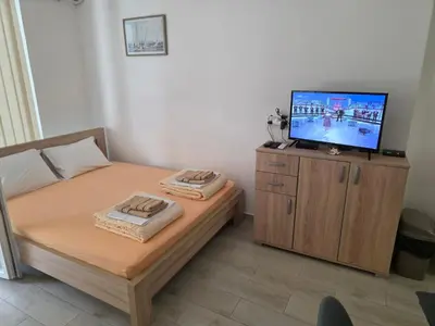a bedroom with a bed with a television on a cabinet at Apartman Tijana in Sutomore