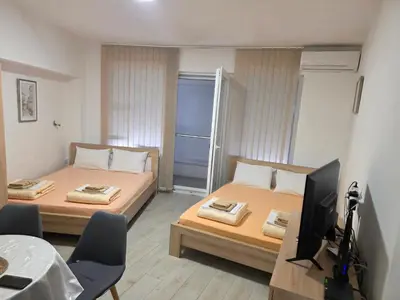 a room with two beds and a television in it at Apartman Tijana in Sutomore