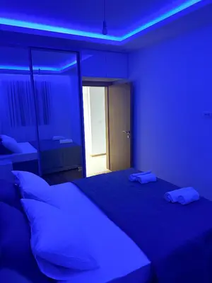 a bedroom with a bed with blue lights on it at Enigma Apartment in Ulcinj