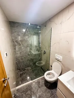 a bathroom with a toilet and a glass shower at Enigma Apartment in Ulcinj