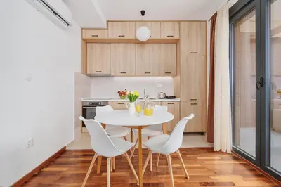 a kitchen with a white table and white chairs at Horizon Bay with Sea View in Kotor