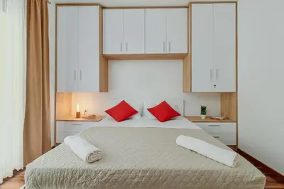 a bedroom with a large bed with red pillows at Horizon Bay with Sea View in Kotor
