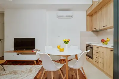 a kitchen with a white table and white chairs at Horizon Bay with Sea View in Kotor