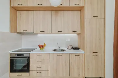 a kitchen with wooden cabinets and a sink at Horizon Bay with Sea View in Kotor