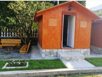a small orange dog house in a yard at House Markovic in Gornja Plavnica