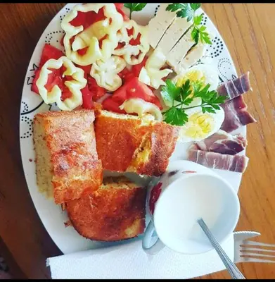 a plate of food with bread and vegetables on a table at House Markovic in Gornja Plavnica