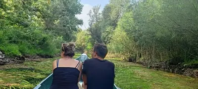 a couple of people riding in a boat on a river at House Markovic in Gornja Plavnica