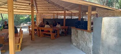 a group of people sitting at a table in a pavilion at House Markovic in Gornja Plavnica