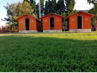 two red buildings in a field of green grass at House Markovic in Gornja Plavnica