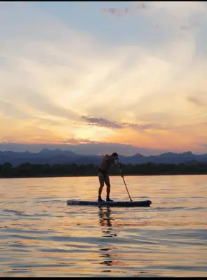 a man on a paddle board in the water at House Markovic in Gornja Plavnica