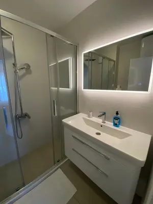 a bathroom with a sink and a shower with a mirror at Sea view and pool! Brend new! Vista in Kotor