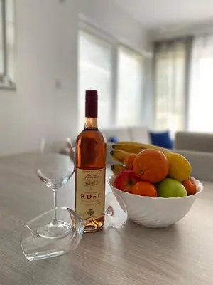 a bottle of wine and a bowl of fruit on a table at Sea view and pool! Brend new! Vista in Kotor