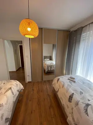 a bedroom with two beds and a chandelier at Sea view and pool! Brend new! Vista in Kotor