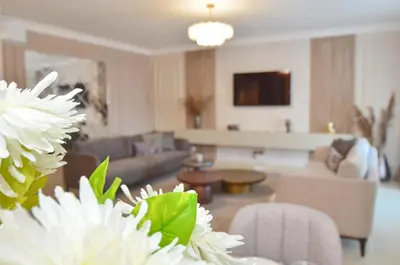 a living room with white flowers in the foreground at Boka Devine Residence in Kotor