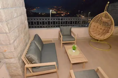 a balcony with a couch and two chairs and a table at Boka Devine Residence in Kotor