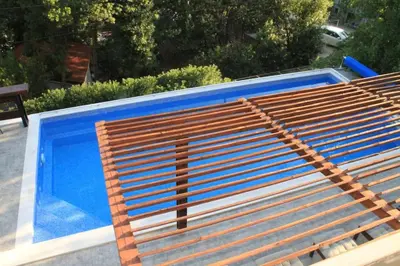 a wooden bench sitting next to a swimming pool at Villa Hedonic in Ulcinj