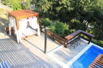 a pool with a table and a bench and a table and a tablektop at Villa Hedonic in Ulcinj