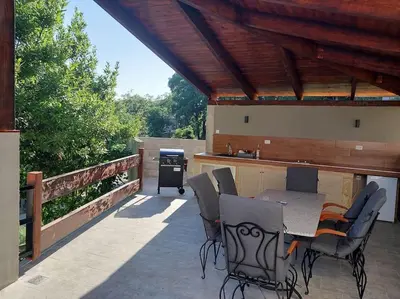 a patio with a table and chairs and a grill at Villa Hedonic in Ulcinj