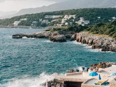 a group of people sitting on the beach near the water at Hayal Boutique Hotel in Bar