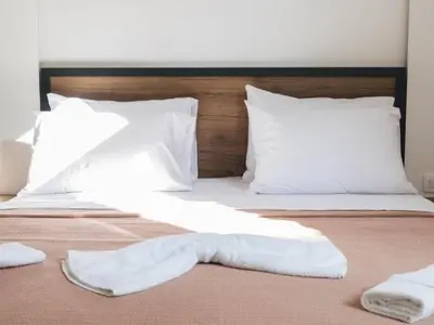 a bed with white sheets and pillows on it at Hayal Boutique Hotel in Bar