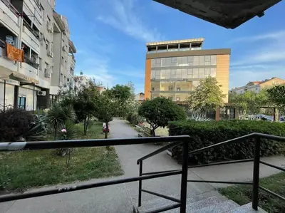 a person walking down a sidewalk in front of a building at Apartment in Podgorica - Montenegro in Konik