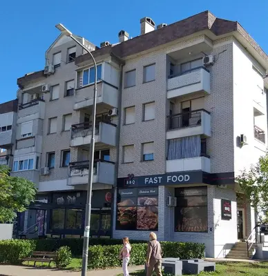two people walking in front of a fast food building at Apartment in Podgorica - Montenegro in Konik