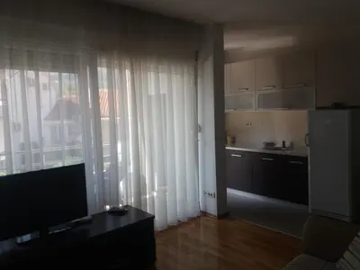 a living room with a large window and a kitchen at Sofia apartment in Budva