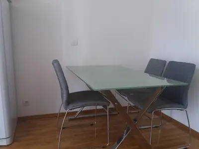 a glass table with four chairs in a room at Sofia apartment in Budva