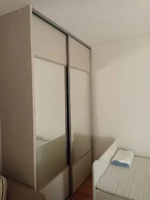 a bedroom with a bed and a mirrored cabinet at Sofia apartment in Budva