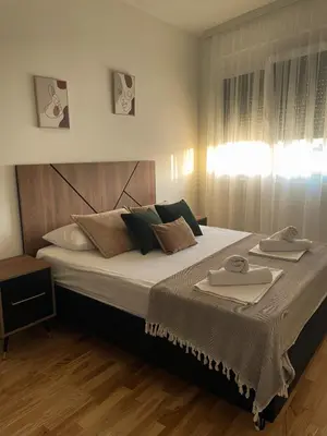 a bedroom with a large bed with two towels on it at Le Vacanze 2 in Ulcinj
