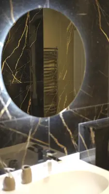 a bathroom with a round mirror above a sink at Sunshine of Montenegro - Luxury in Kotor