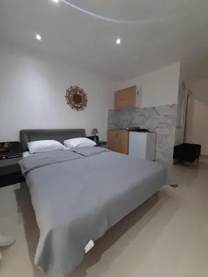 a bedroom with a large bed and a stone wall at Becic Apartments in Ulcinj
