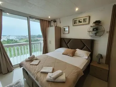 a bedroom with a large bed with a large window at Becic Apartments in Ulcinj