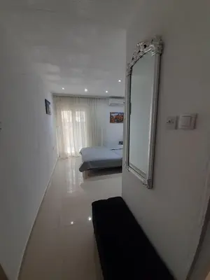 a bathroom with a mirror and a bed in a room at Becic Apartments in Ulcinj