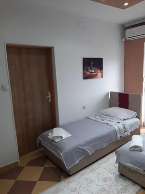 a bedroom with a bed and a wooden door at Becic Apartments in Ulcinj