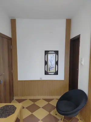 a room with a chair and a mirror on the wall at Becic Apartments in Ulcinj