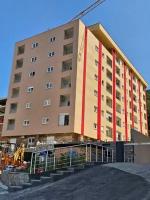 a large building with a red stripe on it at Comfy Nikic Apartments in Budva