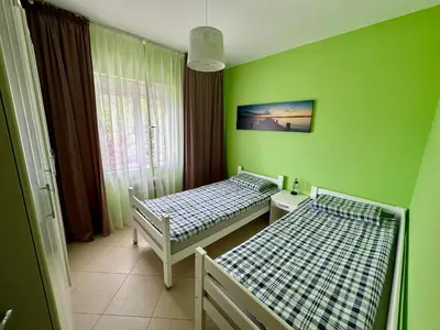 two beds in a room with green walls at Summer Apartment Petrovac in Petrovac na Moru