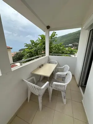 a table and chairs on a balcony with a view at Summer Apartment Petrovac in Petrovac na Moru