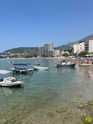 a group of boats in the water near a beach at Apartman Dejan Rafailovici in Rafailovici