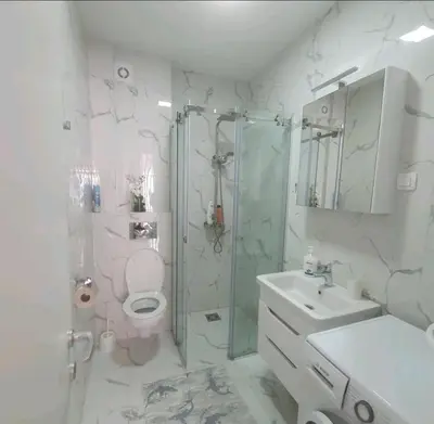a bathroom with a shower and a toilet and a sink at Sirius apartaments in Rafailovici