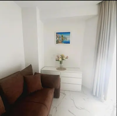 a living room with a couch and a vase of flowers at Sirius apartaments in Rafailovici