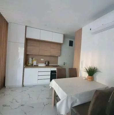 a dining room with a table and a kitchen at Sirius apartaments in Rafailovici