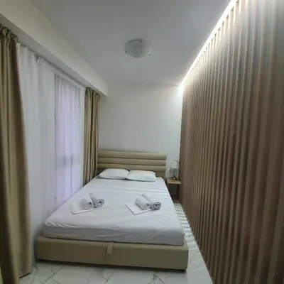 a bedroom with a bed with two towels on it at Sirius apartaments in Rafailovici
