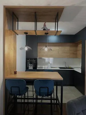 a kitchen with a wooden table and blue chairs at Apartment Minna Master Quart in Podgorica