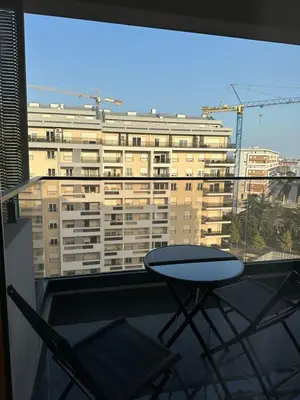 a table and chairs on a balcony with a building at Apartment Minna Master Quart in Podgorica